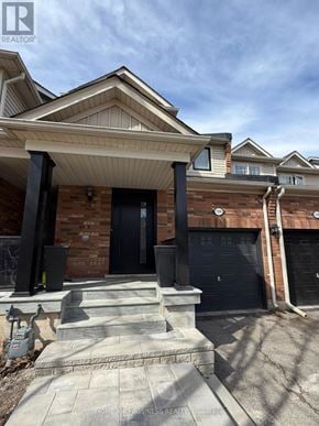 Oakville (Wm Westmount) townhouse for rent - A house with a black door and a garage door is for sale.