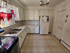 Toronto (Yorkdale-Glen Park) triplex for rent - A kitchen with a refrigerator, sink, and cabinets.
