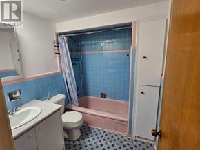Toronto (Yorkdale-Glen Park) triplex for rent - A bathroom with blue tiles and a pink bathtub.