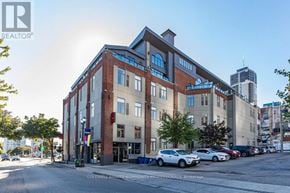 Hamilton (Beasley) condo for rent - A large building with a parking lot in front of it.