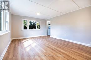 Peterborough (Northcrest Ward 5) apartment for rent - A room with wooden flooring and a window showing trees outside.