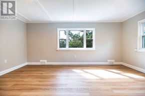 Peterborough (Northcrest Ward 5) apartment for rent - A room with wooden floors and a window showing trees outside.