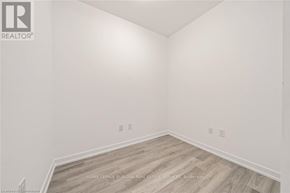 Hamilton (Waterdown) condo for rent - A white room with wooden flooring and a logo on the wall.