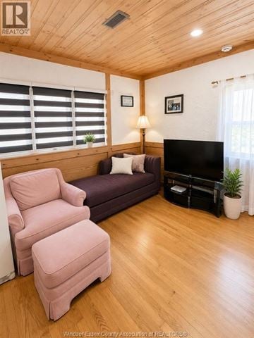 Windsor apartment for rent - A living room with a purple couch, a pink chair, and a flat screen TV.