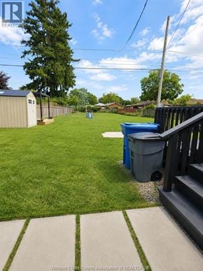 Windsor apartment for rent - A backyard with a blue trash can and a wooden fence.