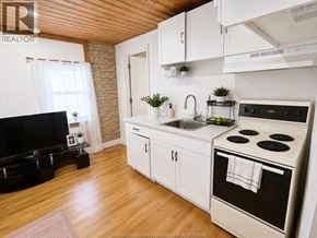 Windsor apartment for rent - A kitchen with white cabinets and a black stove top.