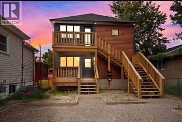 Windsor apartment for rent - A two-story wooden house with a balcony and stairs leading to the upper level.