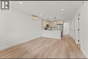 Windsor apartment for rent - A spacious kitchen with white cabinets and a wooden floor.