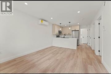 Windsor apartment for rent - A spacious kitchen with white cabinets and a wooden floor.