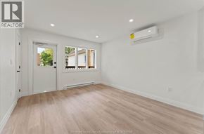 Windsor apartment for rent - A spacious room with a door, a window, and a wall-mounted air conditioner unit.