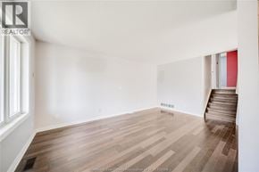 Windsor apartment for rent - A room with wooden flooring and a staircase leading to another room.
