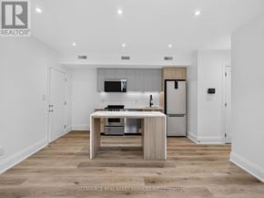 Toronto (Clanton Park) multi-family for rent - A modern kitchen with a wooden island and stainless steel appliances.