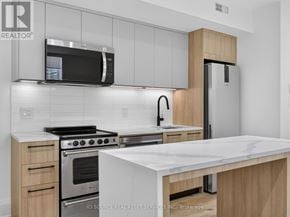 Toronto (Clanton Park) multi-family for rent - A modern kitchen with a stainless steel refrigerator, microwave, and oven.