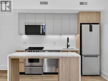 Toronto (Clanton Park) multi-family for rent - A modern kitchen with a stainless steel refrigerator and a wooden island.