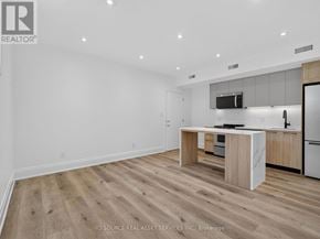 Toronto (Clanton Park) multi-family for rent - A modern kitchen with wooden flooring and white walls.