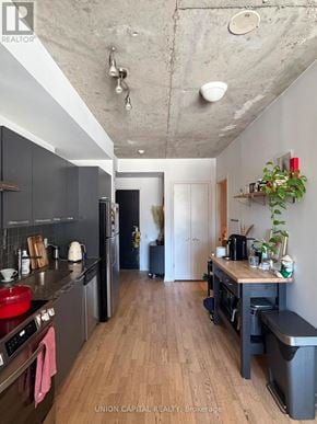 Toronto (Waterfront Communities) condo for rent - A kitchen with wooden floors and a concrete ceiling.
