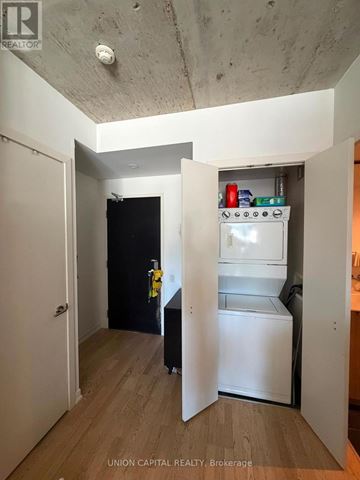 Toronto (Waterfront Communities) condo for rent - A small kitchen with a refrigerator and a black door.