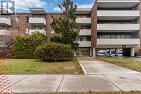 Toronto (Parkwoods-Donalda) condo for rent - A large apartment complex with a parking lot in front.