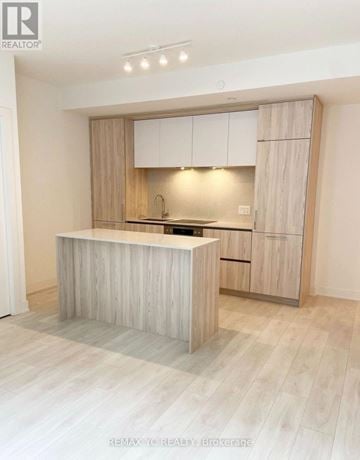 Toronto (Waterfront Communities) condo for rent - A modern kitchen with wooden cabinets and a central island.