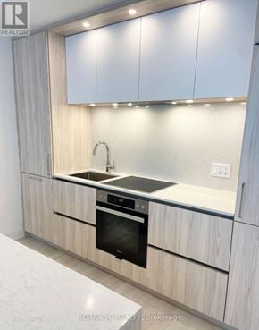 Toronto (Waterfront Communities) condo for rent - A modern kitchen with a sink and stove.