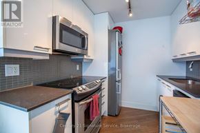 Toronto (Moss Park) condo for rent - A kitchen with a stove, microwave, and refrigerator.