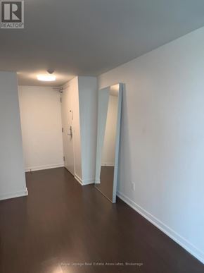 Toronto (Niagara) condo for rent - A white hallway with a door and a mirror on the wall.