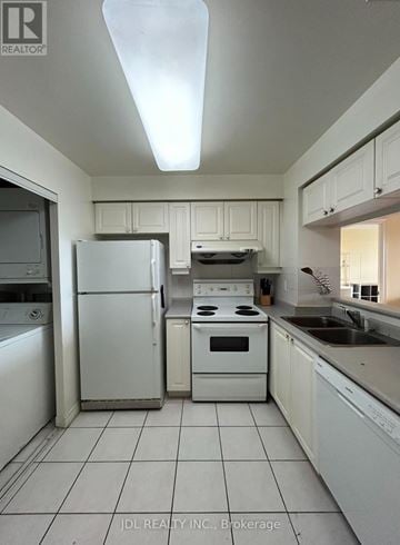 Toronto (Woburn) condo for rent - A white kitchen with a refrigerator, oven, and washing machine.