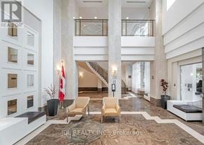 Toronto (Woburn) condo for rent - A spacious lobby with a staircase, chairs, and a reception desk.