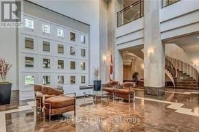 Toronto (Woburn) condo for rent - A spacious lobby with a marble floor and a staircase.