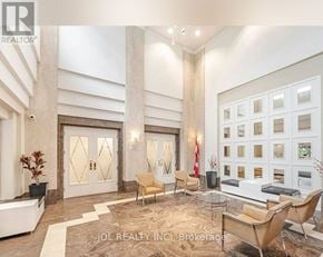 Toronto (Woburn) condo for rent - A spacious living room with a large window, a sofa, a chair, and a coffee table.