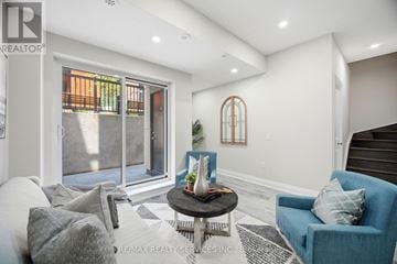 Vaughan (Vaughan Grove) townhouse for rent - A living room with a blue chair and a round table with a vase on it.