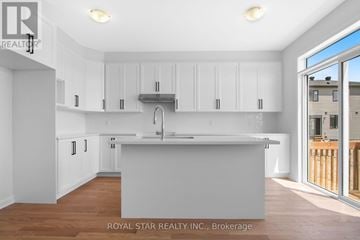 Ottawa apartment for rent - A kitchen with white cabinets and a wooden floor.