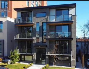 Ottawa apartment for rent - A modern two-story apartment building with balconies and glass doors.