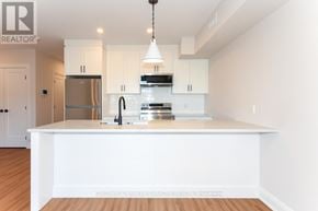 Ottawa apartment for rent - A modern kitchen with white cabinets and a wooden floor.