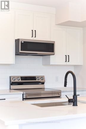 Ottawa apartment for rent - A modern kitchen with a microwave above the stove.