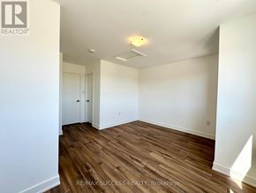 Barrie townhouse for rent - A room with wooden flooring and white walls.