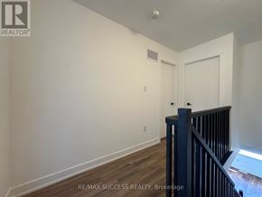 Barrie townhouse for rent - A room with a wooden floor and a white wall with a door and a window.