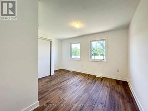 Barrie townhouse for rent - A room with wooden floors and two windows.