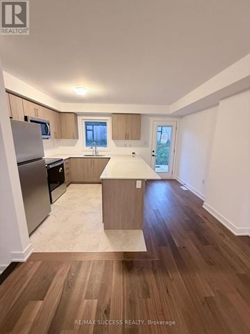 Barrie townhouse for rent - A kitchen with wooden floors and white walls.