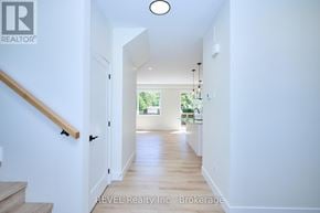 Niagara Falls (Ascot) apartment for rent - A hallway with a wooden staircase and a light on the ceiling.