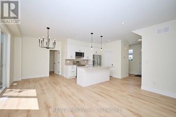 Niagara Falls (Ascot) apartment for rent - A spacious kitchen with white cabinets and a wooden floor.