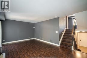 Windsor townhouse for rent - A room with wooden floors and a staircase leading to another room.
