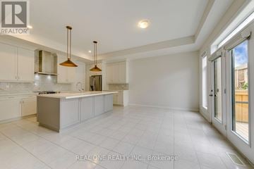 Oakville (Go Glenorchy) apartment for rent - A spacious kitchen with white cabinets and a central island.