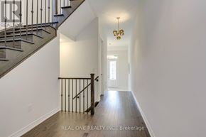 Oakville (Go Glenorchy) apartment for rent - A hallway with a staircase and a chandelier.
