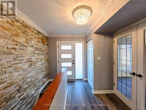 Mississauga (Clarkson) apartment for rent - A hallway with a stone wall and wooden floor.