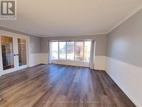 Mississauga (Clarkson) apartment for rent - A spacious room with wooden flooring and a large window.