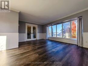Mississauga (Clarkson) apartment for rent - A spacious room with wooden floors and large windows.