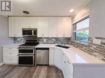 Mississauga (Clarkson) apartment for rent - A kitchen with white cabinets and a stone backsplash.