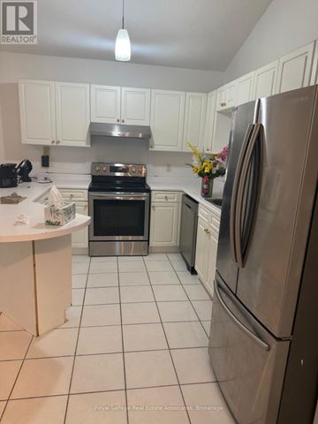 Mississauga (Streetsville) apartment for rent - A kitchen with white cabinets and a stainless steel refrigerator.