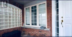 Brampton (Sandringham-Wellington) apartment for rent - A window with a white frame and a black bench in front of it.